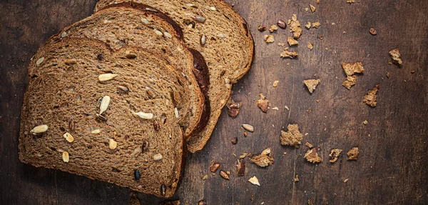 Koyu Ahşap Arka Planda Dilimlenmiş Kepekli Ekmeğin Üst Görüntüsü Tohumlu — Stok fotoğraf