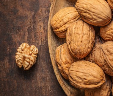 Koyu renk şarap masasında ceviz. Yeşil yapraklı ceviz çekirdekleri. Kopyalama alanı.