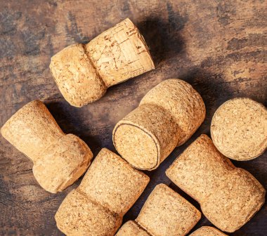 Şarap mantarları ahşap bir masaya yakın çekim yapar. Şarap, şenlik konsepti. Üst Manzara. Düz la