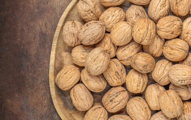 Koyu renk şarap masasında ceviz. Yeşil yapraklı ceviz çekirdekleri. Kopyalama alanı.