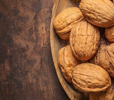 Koyu renk şarap masasında ceviz. Yeşil yapraklı ceviz çekirdekleri. Kopyalama alanı.