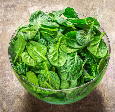 Tahta masadaki bir kasede ıspanak yaprakları. Taze ıspanak Kapanışı.