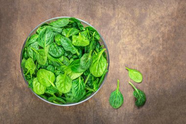  Tahta masadaki bir kasede ıspanak yaprakları. Taze ıspanak kapanışı. Uzayı kopyala Üst yaşam