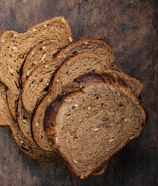 sliced wholegrain bread on dark ructic wooden background closeup. 