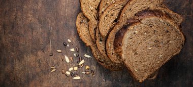 sliced wholegrain bread on dark ructic wooden background closeup. 