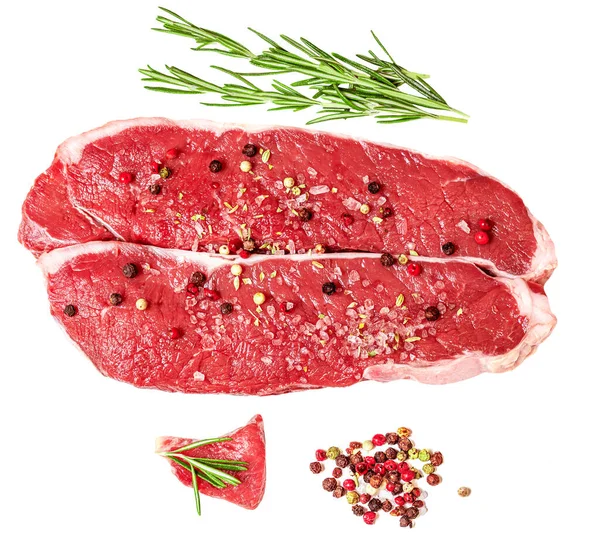 Fresh beef steak isolated on white background, top view. Raw meat fillet with spices and herb