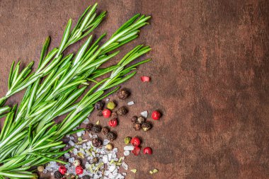 Rosmary bound on a wooden board with spices and copyspace. Top vie