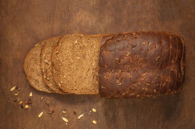 Top view of sliced wholegrain bread on dark ructic wooden background closeup. Top vie