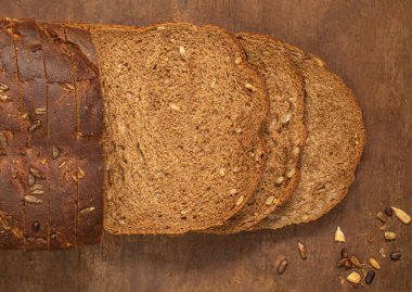 Top view of sliced wholegrain bread on dark ructic wooden background closeup. Top vie