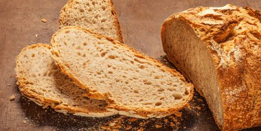 Organic wholegrain bread on dark ructic wooden background closeup. Fresh bread Top view.