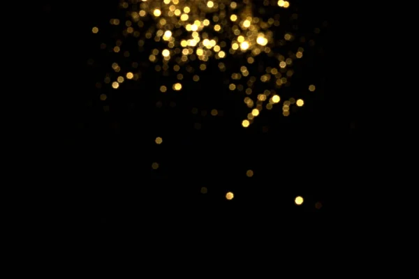 黒の背景に金色のぼやけたボケのライト — ストック写真