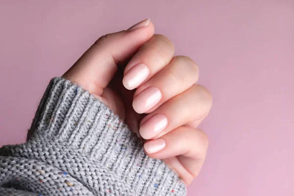 Hand in Hand Pullover mit nackten Nägeln auf rosa Hintergrund — Stockfoto