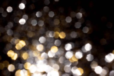Siyah arkaplanda altın ve gümüş bulanık bokeh ışıkları