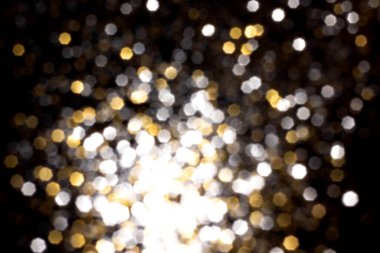 Siyah arkaplanda altın ve gümüş bulanık bokeh ışıkları