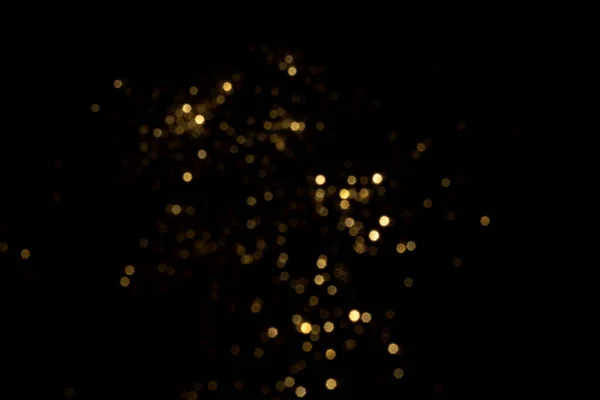 Siyah arkaplanda altın bulanık bokeh ışıkları