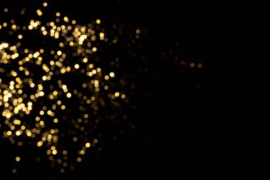 Siyah arkaplanda altın bulanık bokeh ışıkları