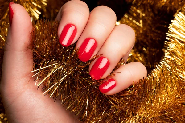 Weibliche Hand Mit Schöner Feiertagsmaniküre Rote Nägel Mit Goldenem Weihnachtslametta — Stockfoto
