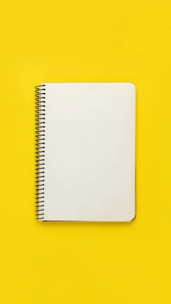 Otwarty notatnik spiralny na żółtym tle — Zdjęcie stockowe