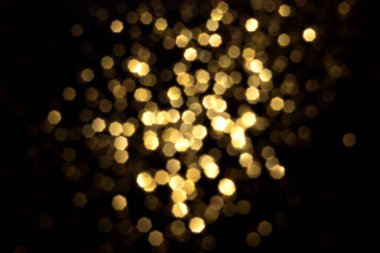 Siyah arka planda altın bulanık bokeh ışıkları. Kutlamak için ışıldayan yıldızlar. Tasarımınız için üstüste