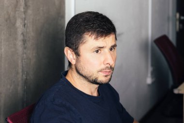 Ofisteki adam beton duvara yaslanmış.