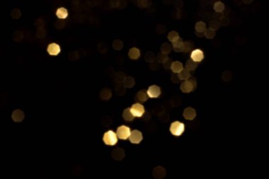 Siyah arkaplanda altın bulanık bokeh ışıkları