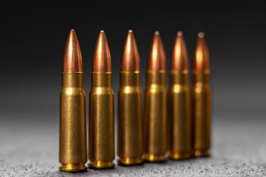 Gri arka plandaki kurşunlar. Kalaşnikof saldırı tüfeği için 7.62 kalibrelik fişekler. Seçici odak