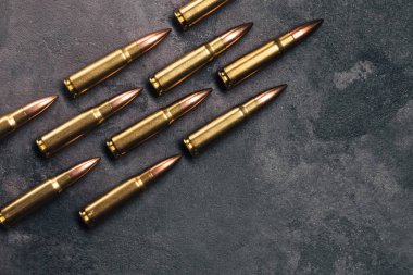 Gri arka plandaki kurşunlar. Kalaşnikof saldırı tüfeği için 7.62 kalibrelik fişekler. Üst görünüm, kopyalama alanı olan düz uzanma