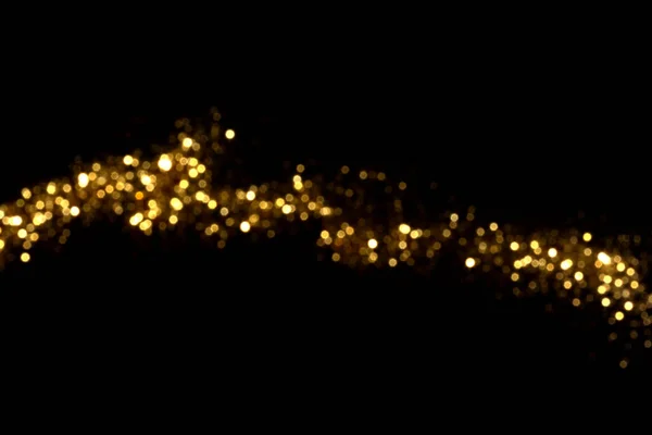 Siyah arka planda altın bulanık bokeh ışıkları. Kutlamak için ışıldayan yıldızlar. Tasarımınız için üstüste