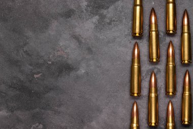 Gri arka plandaki kurşunlar. Kalaşnikof saldırı tüfeği için 7.62 kalibrelik fişekler. Üst görünüm, kopyalama alanı olan düz uzanma