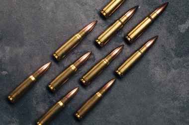 Gri arka plandaki kurşunlar. Kalaşnikof saldırı tüfeği için 7.62 kalibrelik fişekler. Üst manzara, düz uzanma