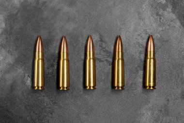 Gri arka plandaki kurşunlar. Kalaşnikof saldırı tüfeği için 7.62 kalibrelik fişekler. Üst manzara, düz uzanma