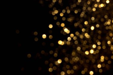 Siyah arka planda altın bulanık bokeh ışıkları. Kutlamak için ışıldayan yıldızlar. Tasarımınız için üstüste