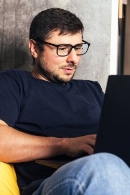 Dizüstü bilgisayarlı gözlüklü sakallı adam