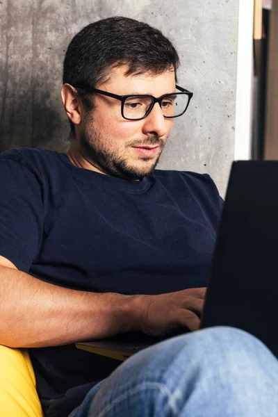 Dizüstü bilgisayarlı gözlüklü sakallı adam