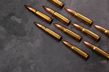 Gri arka plandaki kurşunlar. Kalaşnikof saldırı tüfeği için 7.62 kalibrelik fişekler. Üst görünüm, kopyalama alanı olan düz uzanma