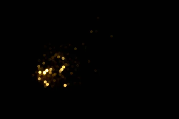 Golden blurred bokeh lights on black background — Stock Photo, Image