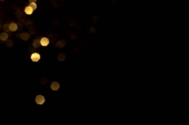 Siyah arka planda altın bulanık bokeh ışıkları. Kutlamak için ışıldayan yıldızlar. Tasarımınız için üstüste