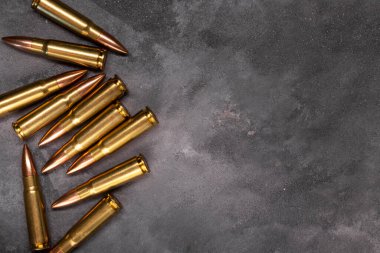 Gri arka plandaki kurşunlar. Kalaşnikof saldırı tüfeği için 7.62 kalibrelik fişekler. Üst görünüm, kopyalama alanı olan düz uzanma