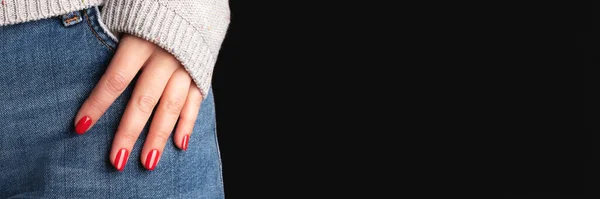 stock image Female hand with beautiful manicure - red nails on jeans denim textile and black background with copy space banner. Wide panoramic header