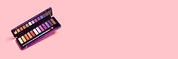 Colorida paleta de sombra de ojos en banner de fondo rosa — Foto de Stock