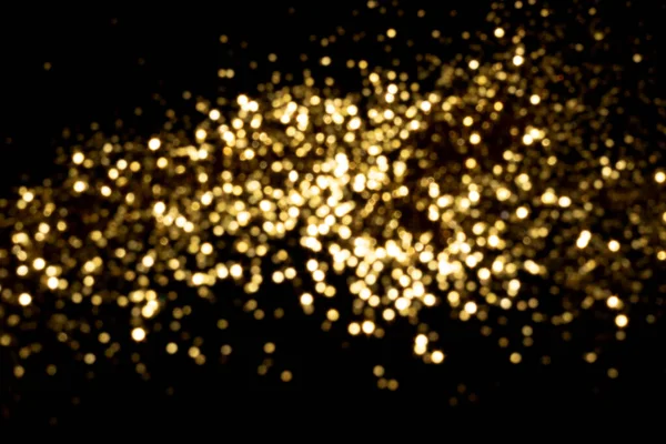 Luzes bokeh embaçadas douradas no fundo preto — Fotografia de Stock
