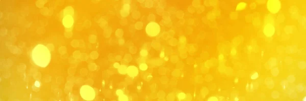 Bright yellow sparkling glitter bokeh background, banner texture. Abstract defocused lights header. Wide screen wallpaper. Panoramic web banner with copy space for design