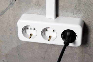 Gri beton duvarlı bir grup beyaz Avrupa elektrik prizi. Seçici odak