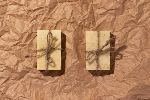 Natural handmade soaps on brown crumpled, wrinkled recycle craft paper background, top view. Zero waste, eco friendly vegan soap bars