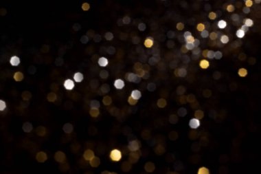 Altın ve gümüş, siyah arka planda bulanık bokeh ışıkları. Kutlamak için ışıldayan yıldızlar. Tasarımınız için üstüste