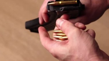 Male hands loading Kalashnikov assault rifle magazine with cartridges. Load magazine with bullets 7.62 caliber for ak 47 closeup