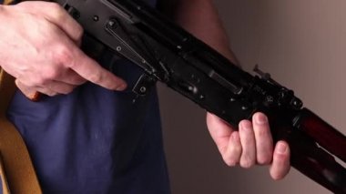 Adam Kalaşnikov saldırı tüfeğinde fişek olmadığını kontrol ediyor, AK-47.
