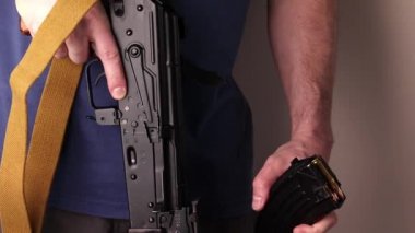 Man attaches ak-47 magazine with cartridges and reloads Kalashnikov assault rifle