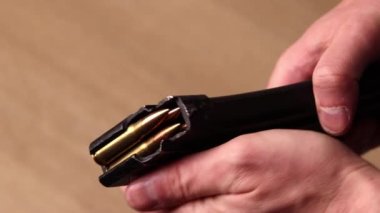 Male hands with Kalashnikov assault rifle magazine with cartridges. Magazine with bullets 7.62 caliber for ak 47 closeup