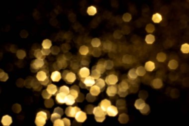 Siyah arka planda altın bulanık bokeh ışıkları. Kutlamak için ışıldayan yıldızlar. Tasarımınız için üstüste